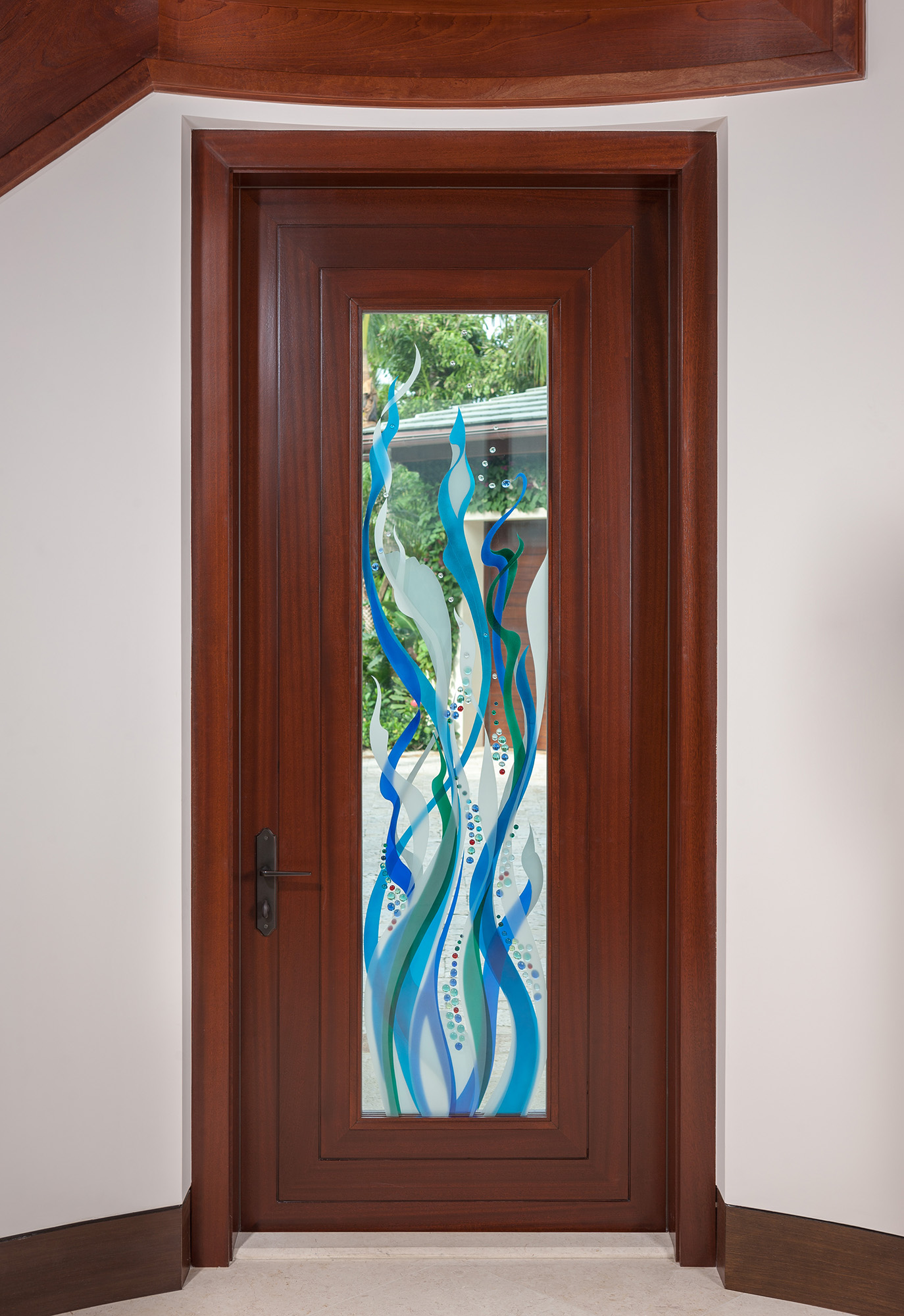 Doorway with a modern and contemporary style of white, blue, and green colored glass.