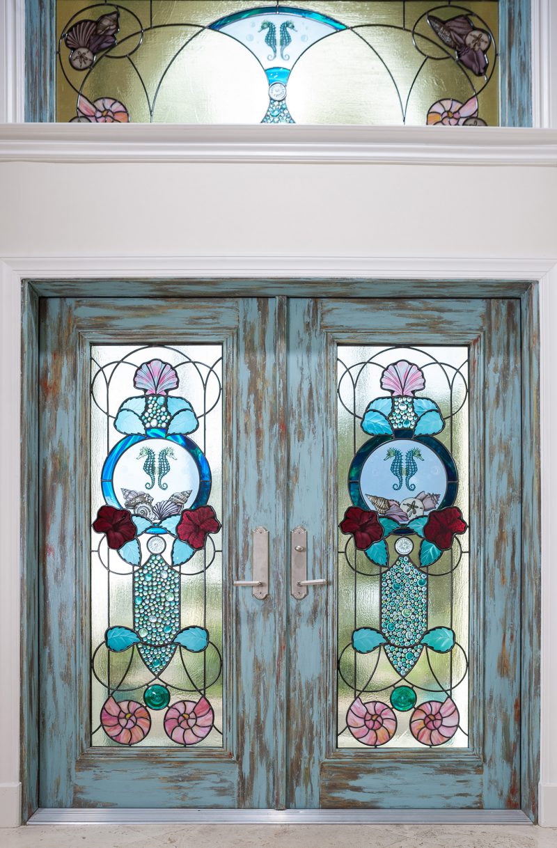 Contemporary style entryway with blue, pink, and red colored glass and glass painting of seashells and seahorses.