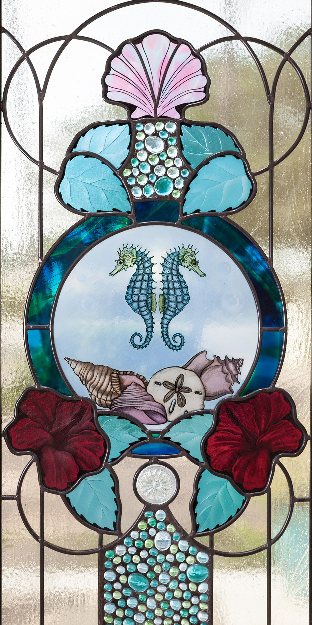 Contemporary style stained glass door with glass paintings of seahorses and seashells and blue, red, and pink colored glass.