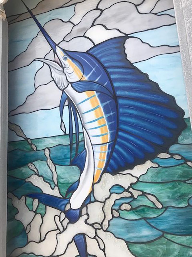 Stained glass mosaic of a sailfish with blue and green glass and glass painting in a Contemporary style.