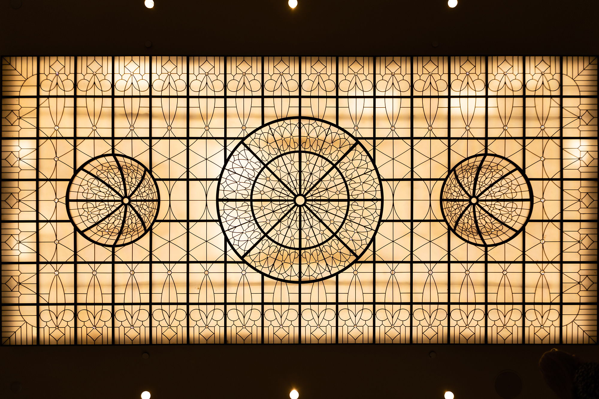 areal view of stained glass skylight. soft ambers and traditional leaded design. 3 arched domes within design