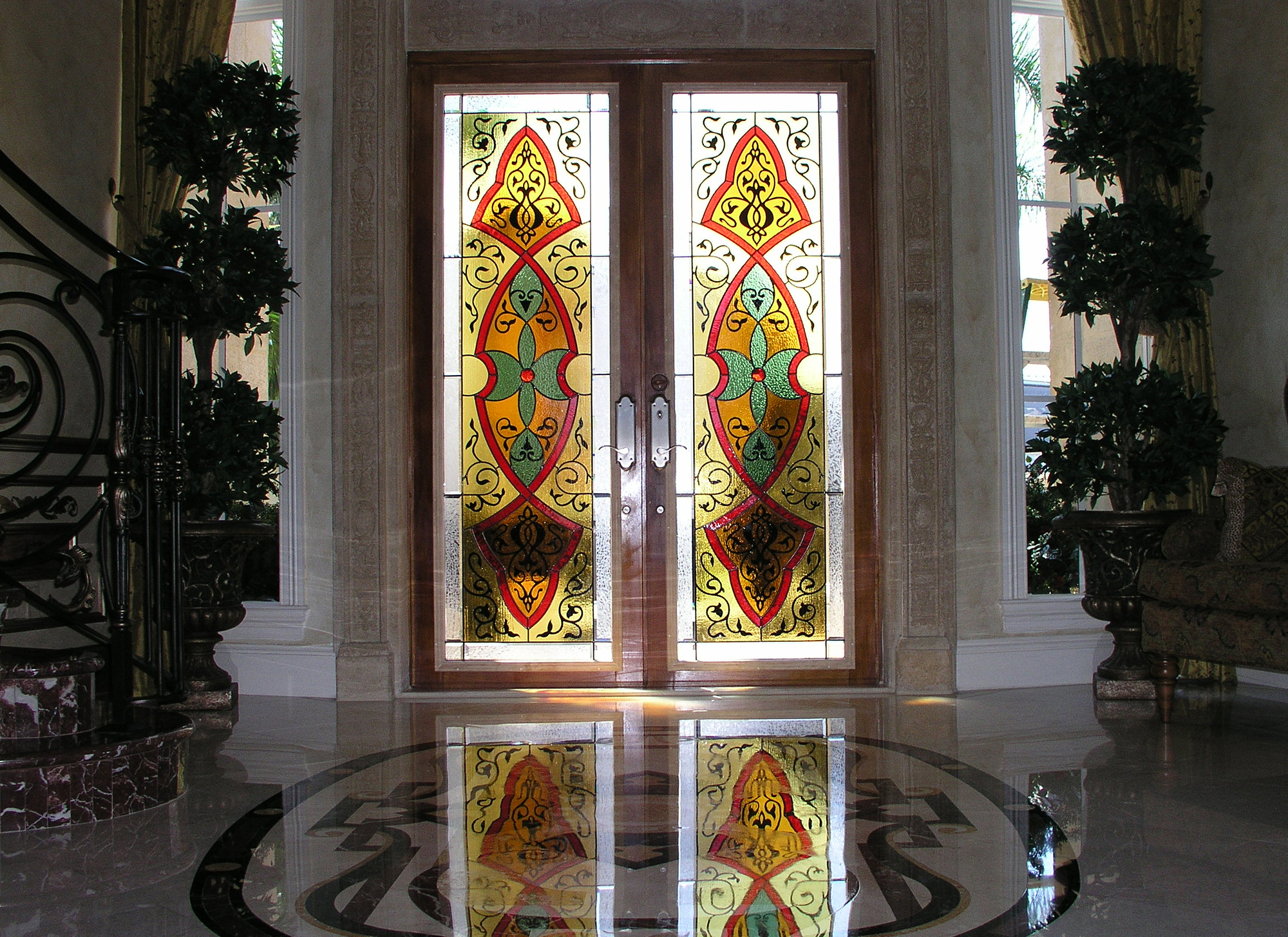 Traditional style entryway with red, yellow, green, and clear textured glass as well as glass painting.