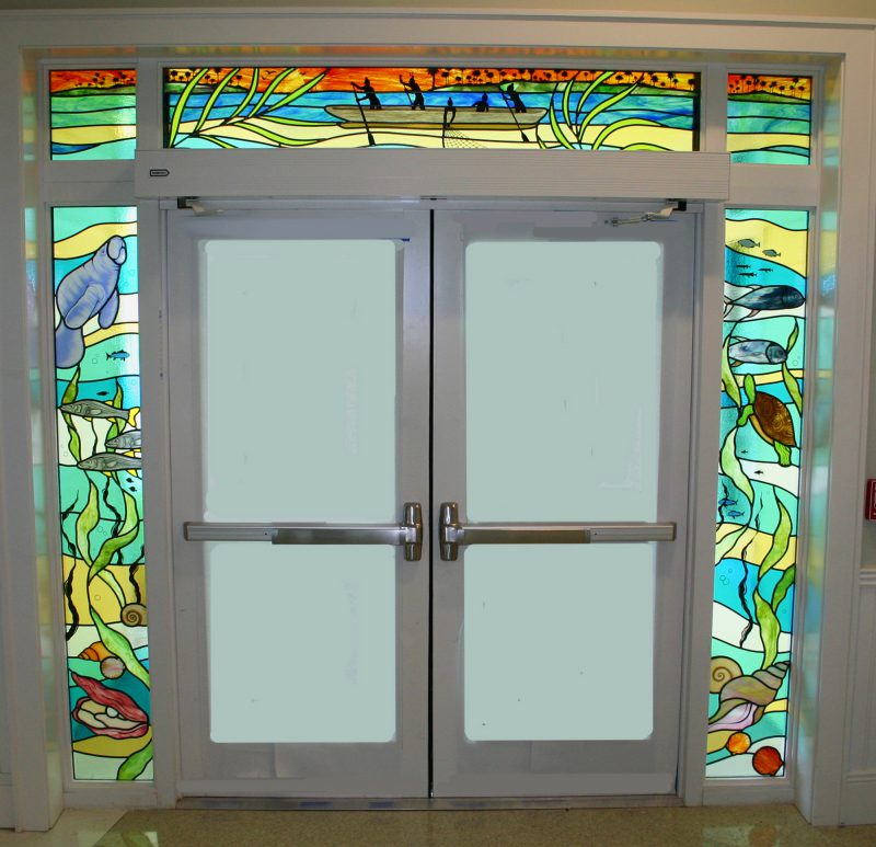 Entryway of underwater manatees and turtles with blue and green colored glass in a traditional style.