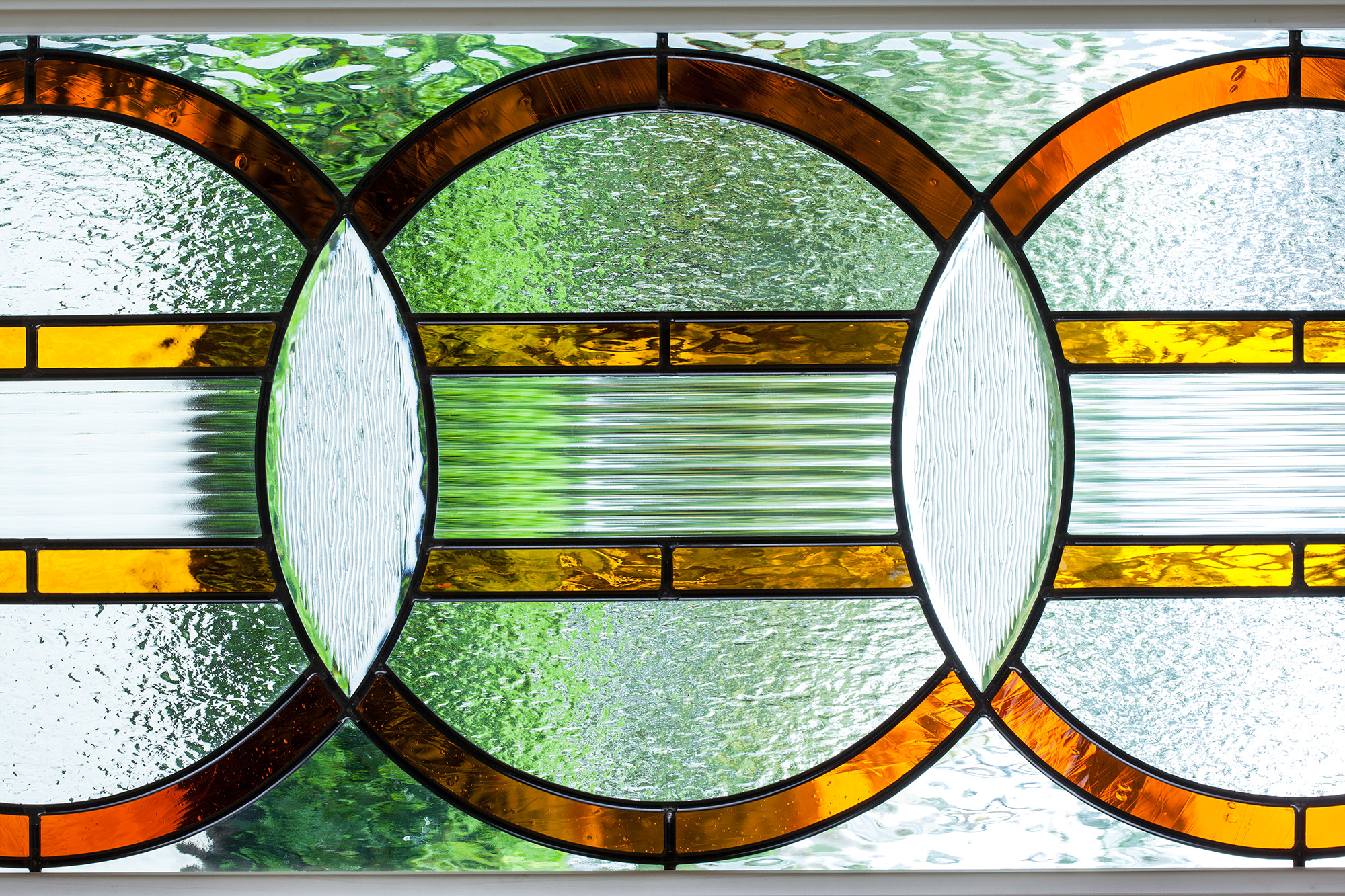 detail photo of art glass window with amber and red glass and textured clear bevels
