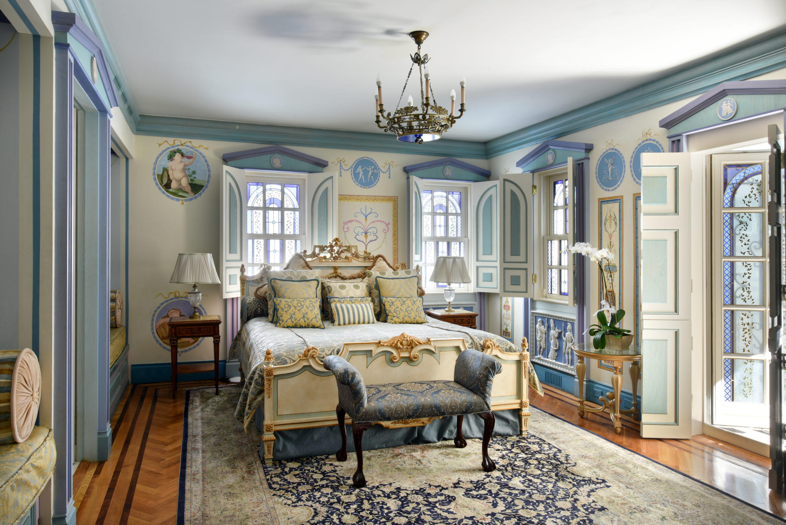 traditional style bedroom space. soft blue, lavender and beige colors. stained glass windows in 4 areas