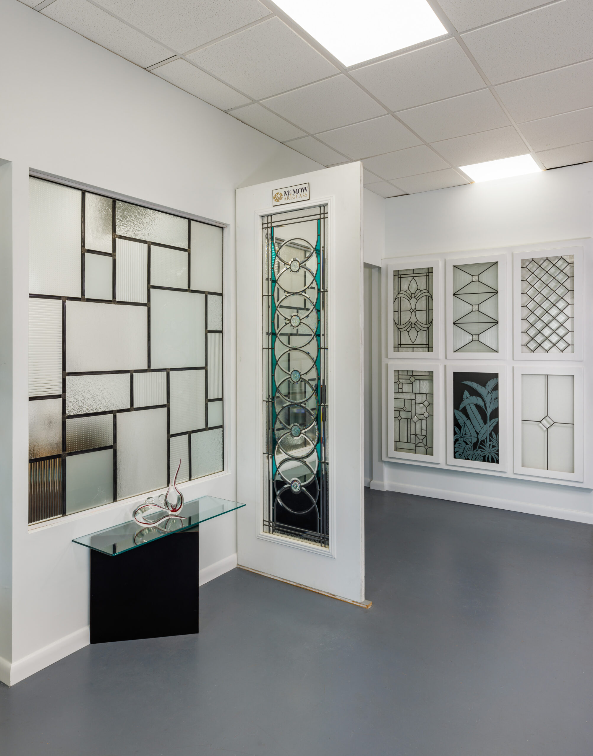 interior showroom space with white door, decorative stained glass in multiple areas